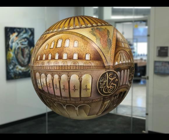 Painted sphere featuring detailed domed architecture and arches