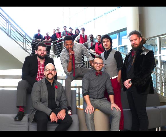Adults in grey, black, and red smiling for a picture