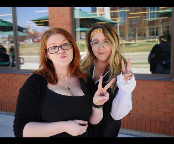 Ladies smiling for picture and holding up a peace sign