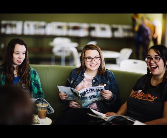 Ladies holding magazines and laughing together