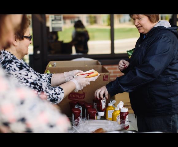 Serving hotdogs to people outside